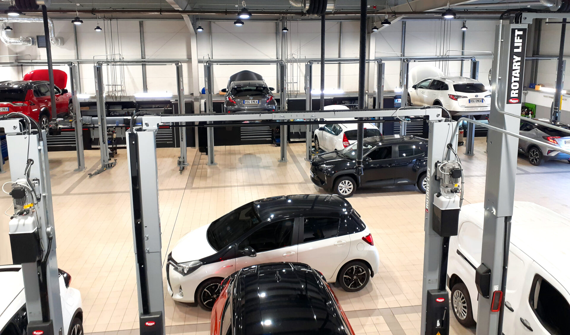 Overview of a repair shop containing cars and workshop equipment