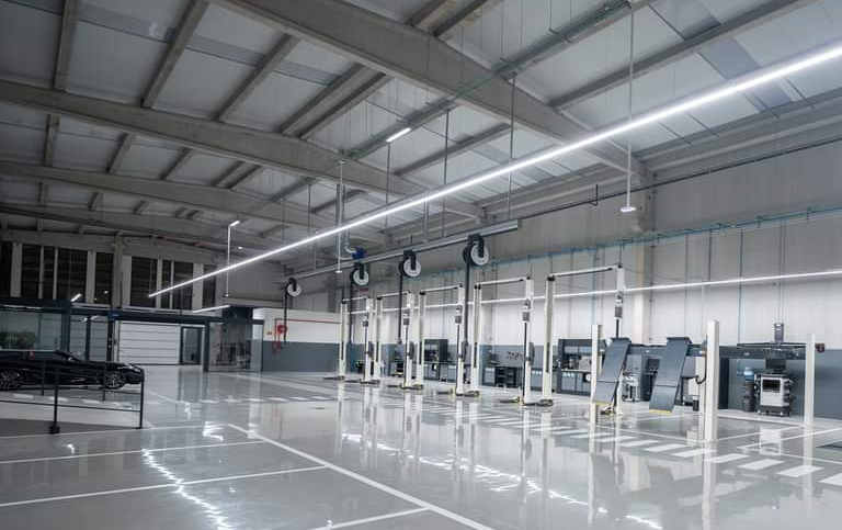 A range of white garage equipment are positioned in a dealership workshop